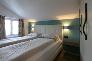 a bedroom with a large white bed with green walls at Appartamenti Guana in Livigno