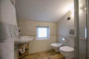 a bathroom with a sink and a toilet and a window at Appartamenti Guana in Livigno