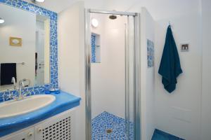 a blue and white bathroom with a sink and a shower at Villa Azzurra in Conca dei Marini
