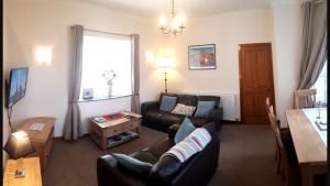 a living room with a couch and a table at Elgin Self Catering Holiday Cottage in Elgin