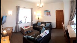 uma sala de estar com um sofá e uma mesa em Elgin Self Catering Holiday Cottage em Elgin