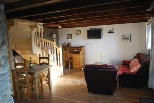 a living room with a red couch and a table at Tanyresgair Cottages in Aberystwyth