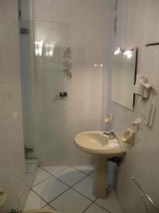 a white bathroom with a sink and a shower at Villa Alma in Bologna
