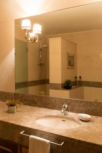 a bathroom with a sink and a large mirror at Apartamento com Piscina in Cruz Quebrada