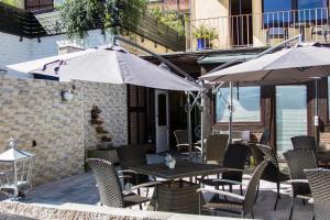 un patio al aire libre con mesas, sillas y una sombrilla en Hotel Altstadtwiege en Hameln