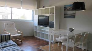salon ze stołem i telewizorem w obiekcie Apartamento playa Isla de Arosa w mieście Isla de Arosa