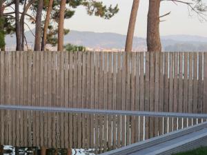 drewniany płot z palmami w tle w obiekcie Apartamento playa Isla de Arosa w mieście Isla de Arosa