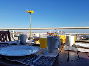 a wooden table with a plate of food and drinks at Spectacular Views Penthouse Apartment in Vila Nova de Gaia