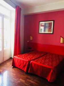 a red room with a bed with a red wall at Residencial Chafariz /Queimada in Funchal