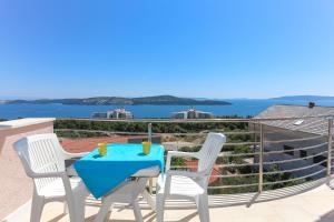 una mesa y sillas en un balcón con vistas al agua en Villa Luciana, en Trogir