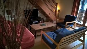 a living room with a couch and a table at Appartement la Charbonnière in Bellefosse