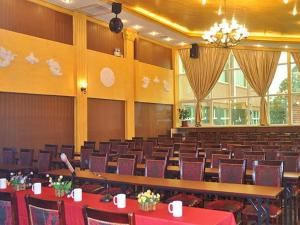 une salle de conférence avec des tables et des chaises ainsi qu'un lustre dans l'établissement Greentree Inn Shanghai Chongming Bao Town Express Hotel, à Chongming