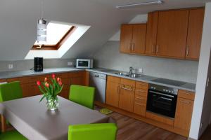 a kitchen with a table with a vase of flowers on it at Turm im Blick in Dietingen