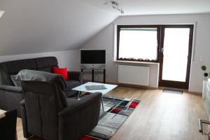 a living room with two couches and a tv at Turm im Blick in Dietingen