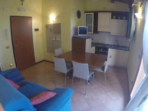 カオルレにあるAppartamento Lucia Con Vista Mareのキッチン(青いソファ、テーブル、椅子付)
