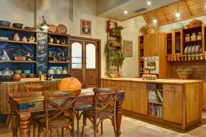 a kitchen with a wooden table and chairs at Gastronomy Hotel Kritsa in Portaria