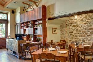 a restaurant with wooden tables and a stone wall at Gastronomy Hotel Kritsa in Portaria