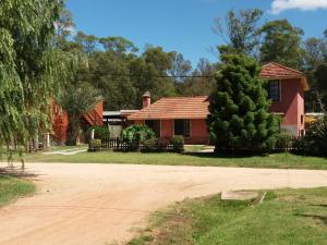 una casa roja con un árbol delante en Villa Cristina, en Punta del Este