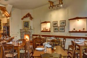 a restaurant with wooden tables and a fireplace at Gastronomy Hotel Kritsa in Portaria