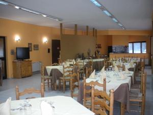 a dining room with tables and chairs and a tv at Hotel La Fattoria in Camigliatello Silano