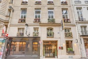 un grand bâtiment avec des fenêtres et des plantes. dans l'établissement Hotel Opera Maintenon, à Paris