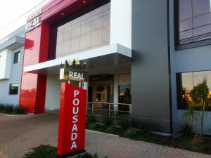 a red realtor sign in front of a building at Hotel Pousada Real in Sinop
