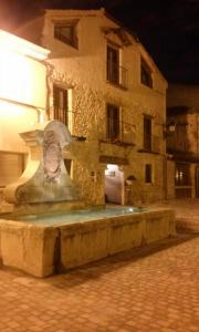 un bâtiment avec une fontaine en face d'un bâtiment dans l'établissement La Casa Vieja, à Turégano