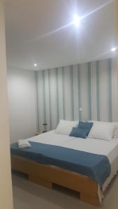 a bedroom with a large bed with a blue blanket at Apto T1 Comfort in Praia