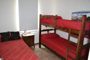 1 dormitorio con 2 literas y manta roja en Cabañas Rincon de Campo San Andres De Las Sierras en Villa Ventana