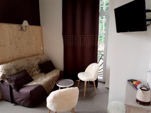 a living room with a couch and two chairs at Le Pavillon in La Bourboule