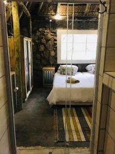 a bedroom with a bed in a stone room at Sasa Safari Camp & Tours in Outjo