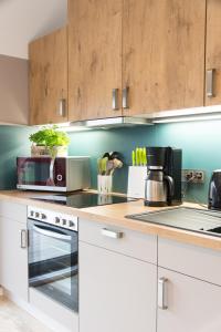 a kitchen with white appliances and wooden cabinets at LANDLOFT am Paradies in Westerstede