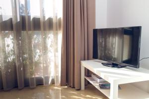 una televisione su un tavolo bianco di fronte a una finestra di Casa Stoccolma a Pozzallo