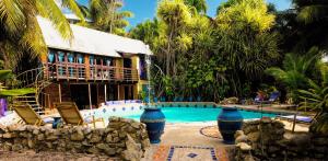un complexe avec une piscine entourée de chaises et un bâtiment dans l'établissement ABEZZA Resort And Spa - formerly Belize Boutique Resort & Adventure Spa, à Maskall