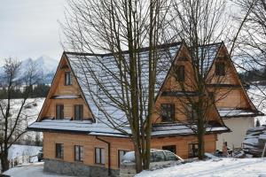 ブコビナ・タトシャンスカにあるKu Sośnieの雪中の大木造家屋