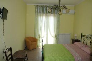 een slaapkamer met een groen bed en een raam bij B&B Grande Salento in San Marzano di San Giuseppe
