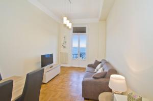 a living room with a couch and a television at PROMENADE HOLIDAY - ROCAMARE PROMENADE in Nice