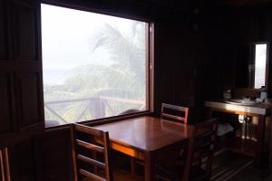 a dining room with a table and a large window at Cabañas El Cuyo in El Cuyo