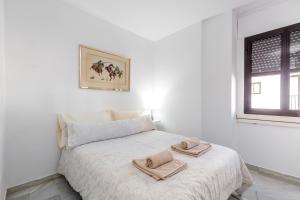 マルベーリャにある2 bedroom apartment in Puerto Banusの白いベッドルーム(タオル付きのベッド付)