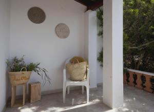 un porche con 2 sillas y una mesa en Viviendas Los Olivos - Formentera Break, en Playa de Migjorn