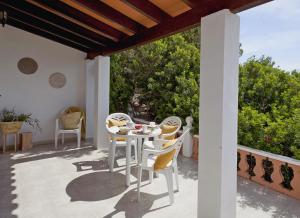 een patio met een tafel en stoelen op een balkon bij Viviendas Los Olivos - Formentera Break in Playa Migjorn