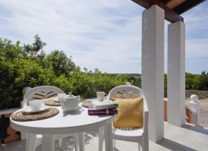a white table and chairs on a patio at Viviendas Los Olivos - Formentera Break in Playa Migjorn