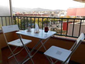 サン・フェリウ・デ・ギホルスにあるhabitación en apartamento compartidoの白いテーブルと椅子、景色を望むバルコニー