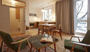 sala de estar con mesa y sillas y cocina en Warsaw Concierge Saska Studio, en Varsovia