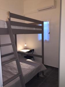 カップ・ダグドにあるMaison Le Jean Bartの二段ベッド2台、デスクが備わる客室です。