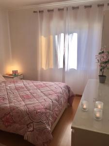 1 dormitorio con 1 cama y una ventana con velas en Viana do Castelo, Cabedelo Beach Apartment, en Viana do Castelo