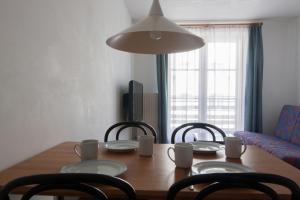 a dining room table with chairs and a table and a lamp at Appartements Christophorus in Bad Hofgastein