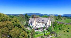 an aerial view of a large house in the forest at The French Country House, Tauranga in Omokoroa Beach