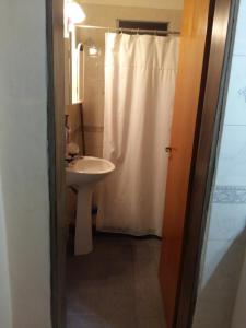 a bathroom with a white shower curtain and a sink at "Mi Casa" in Villa General Belgrano +10 photos