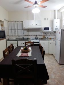 a kitchen with a table and chairs and a refrigerator at "Mi Casa" in Villa General Belgrano